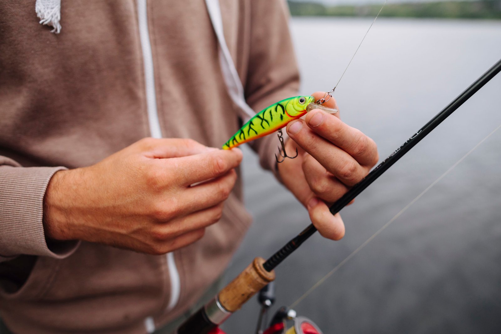 close-up-man-tying-lure-fishing-hook
