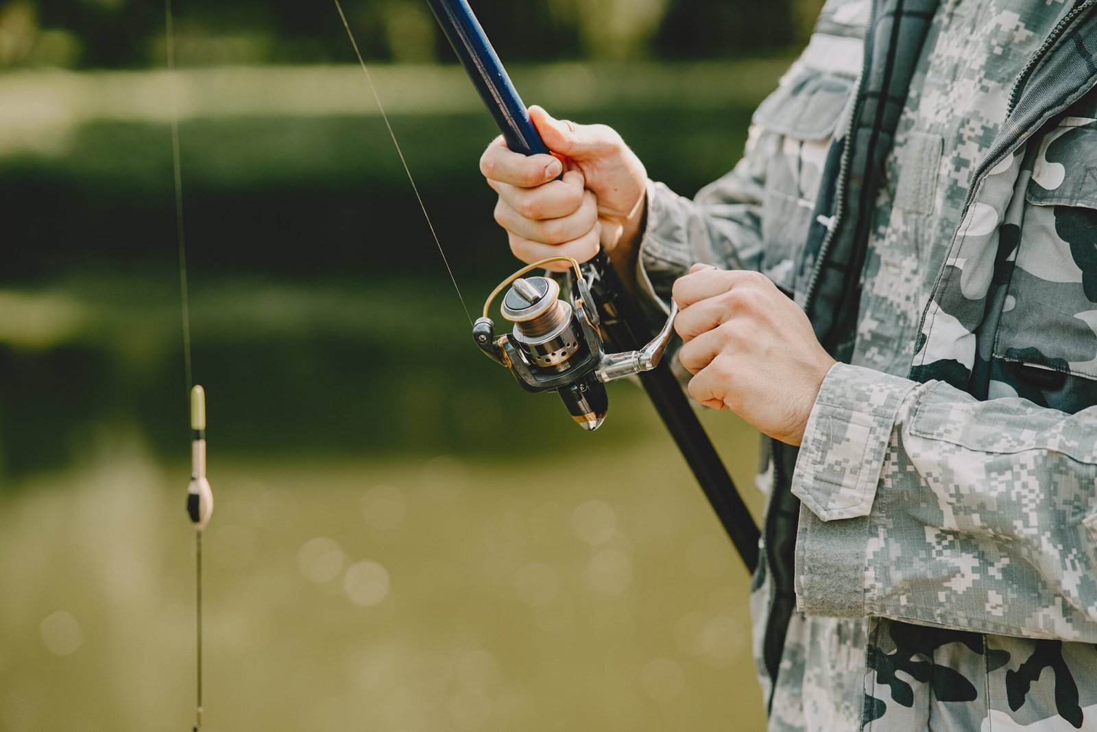 A man fishing on a lake. Guy in a uniform.